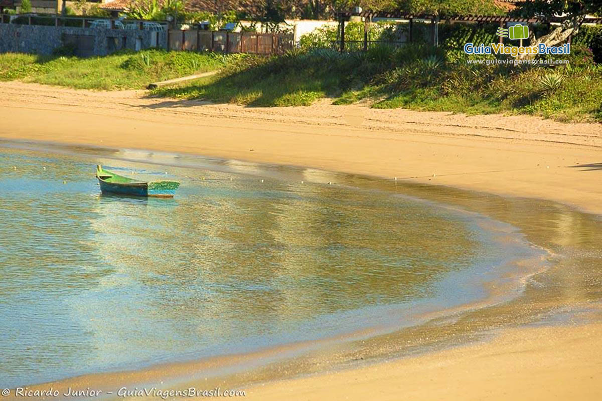 Imagem de barco de pescador na beira da Praia da Ferradura.