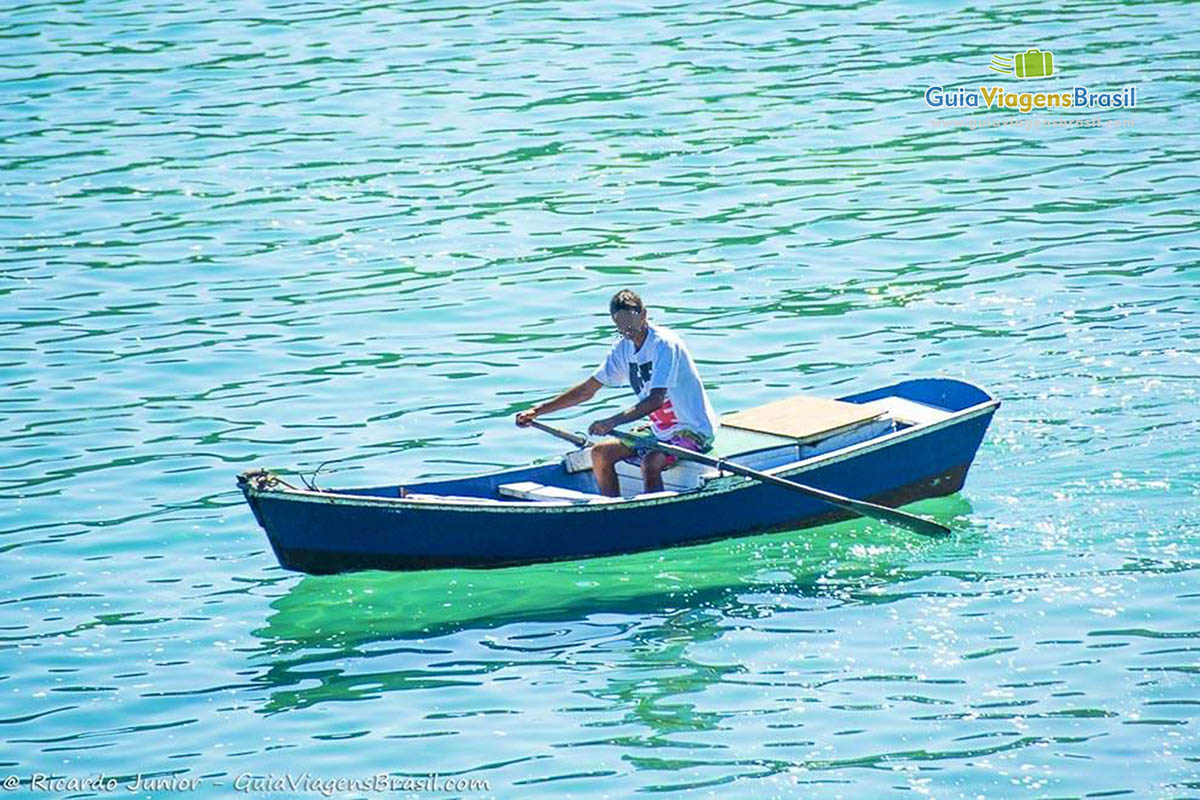 Imagem de uma pessoa remando em um pequeno barco.