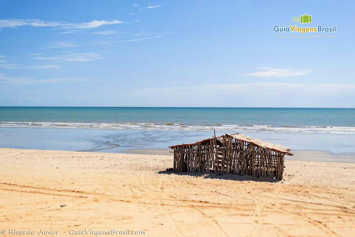 Imagem de  barraca de bambu na areia da praia.