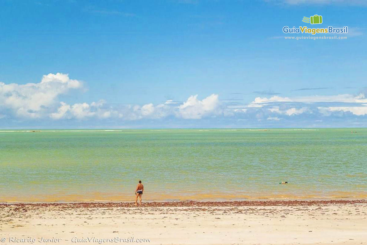 Imagem  de rapaz admirando o mar da Praia Formosa.