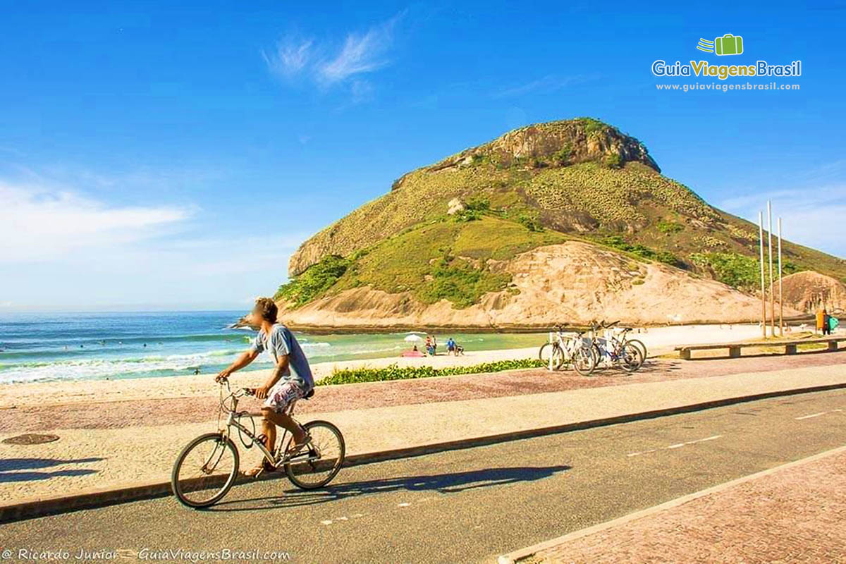 Imagem de uma pessoa andando de bicicleta na Praia do Recreio.
