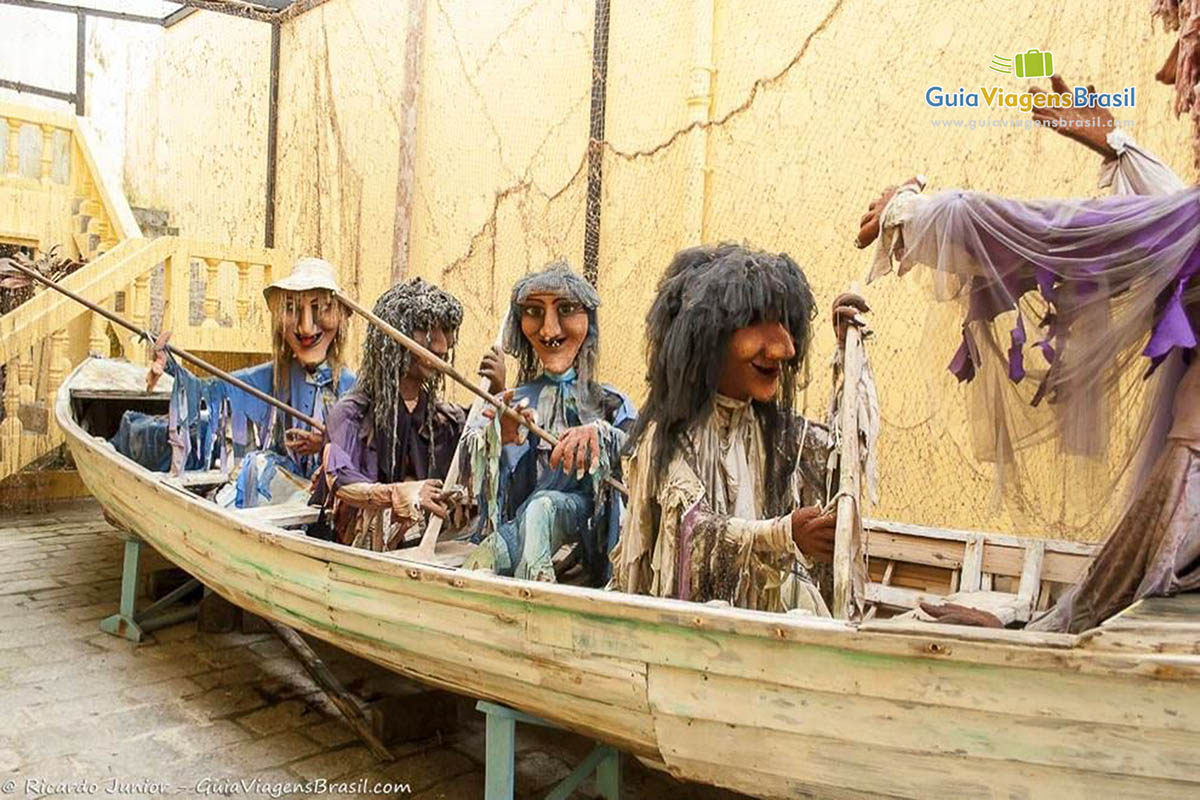 Imagem de bonecos de bruxas dentro de um barco pescador no Museu.