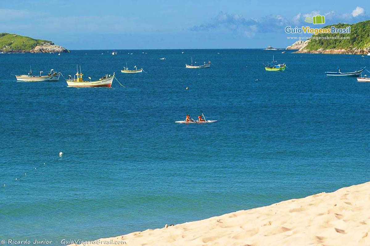 Imagem de caiaque e barcos no mar azul da Praia Ingleses.