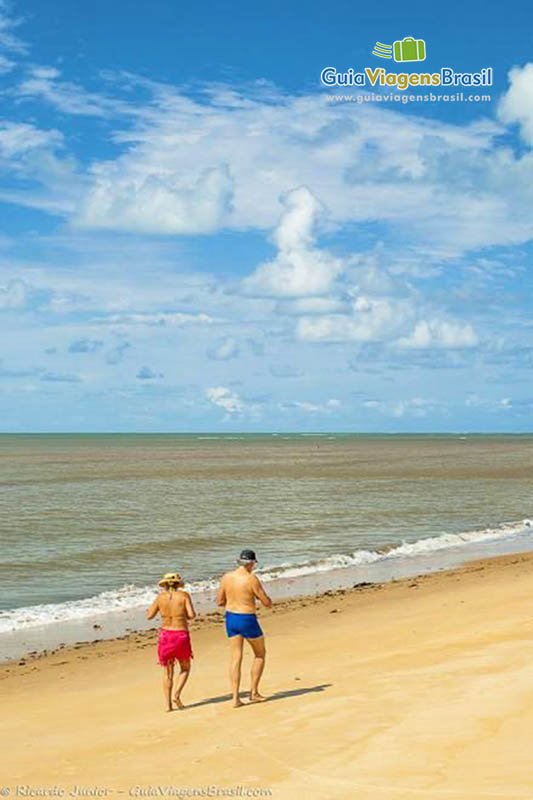 Imagem de casal caminhando na Praia Guaiu.