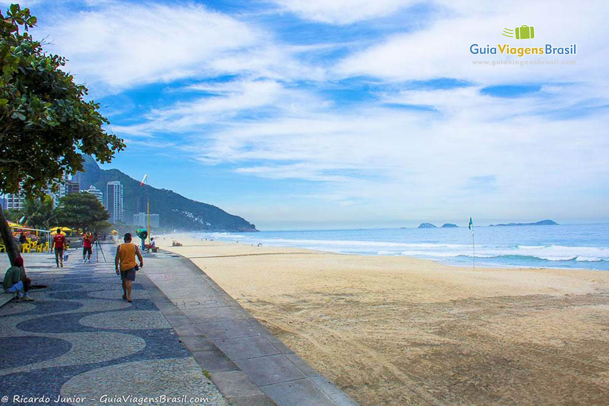 Imagem de uma pessoa caminhando na Praia de São Conrado.