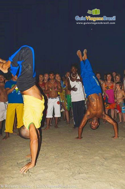 Imagem de pessoas jogando capoeira a noite a Praia Jericoacoara.