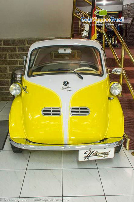 Imagem de um carro antigo, amarelo da BMW.
