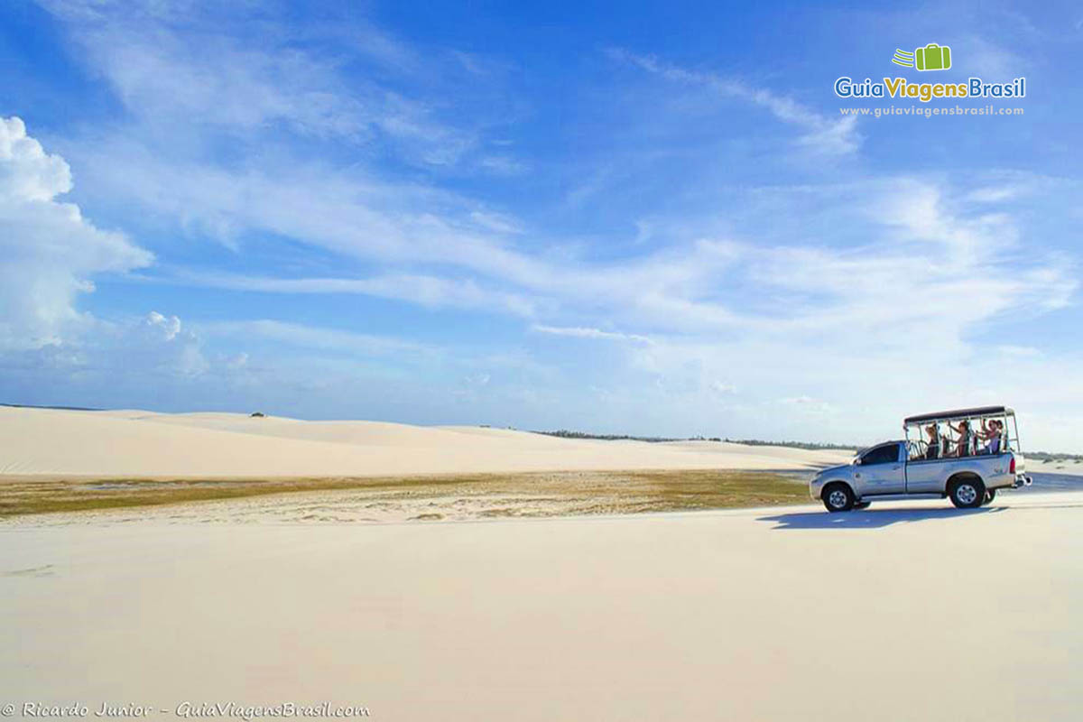 Imagem de carro de passeio sobre as dunas.