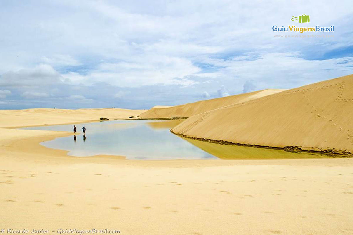 Imagem de turistas andando nas águas e nas dunas do Circuito Cabure.