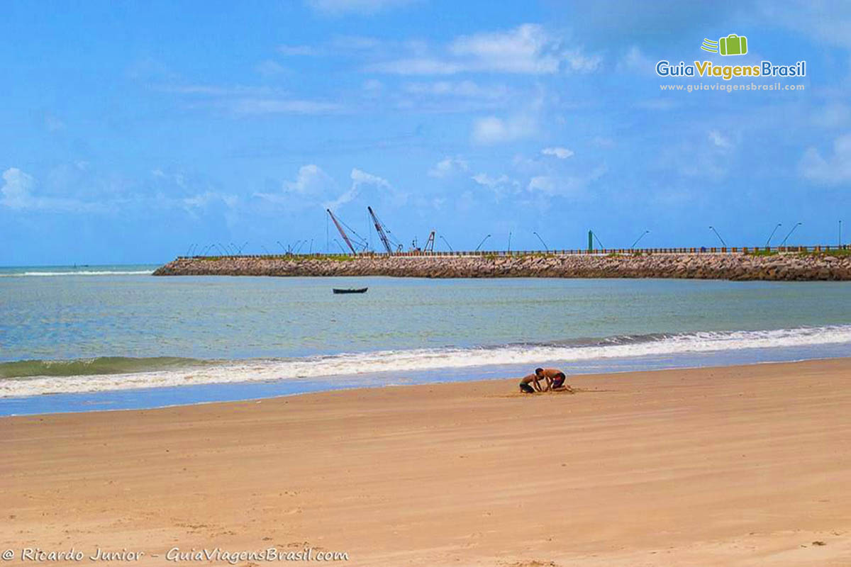Imagem de duas crianças brincando na beira da Praia Rendinha.