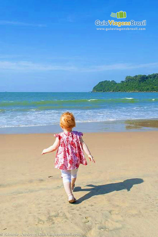 Imagem de uma criança andando em direção ao mar.
