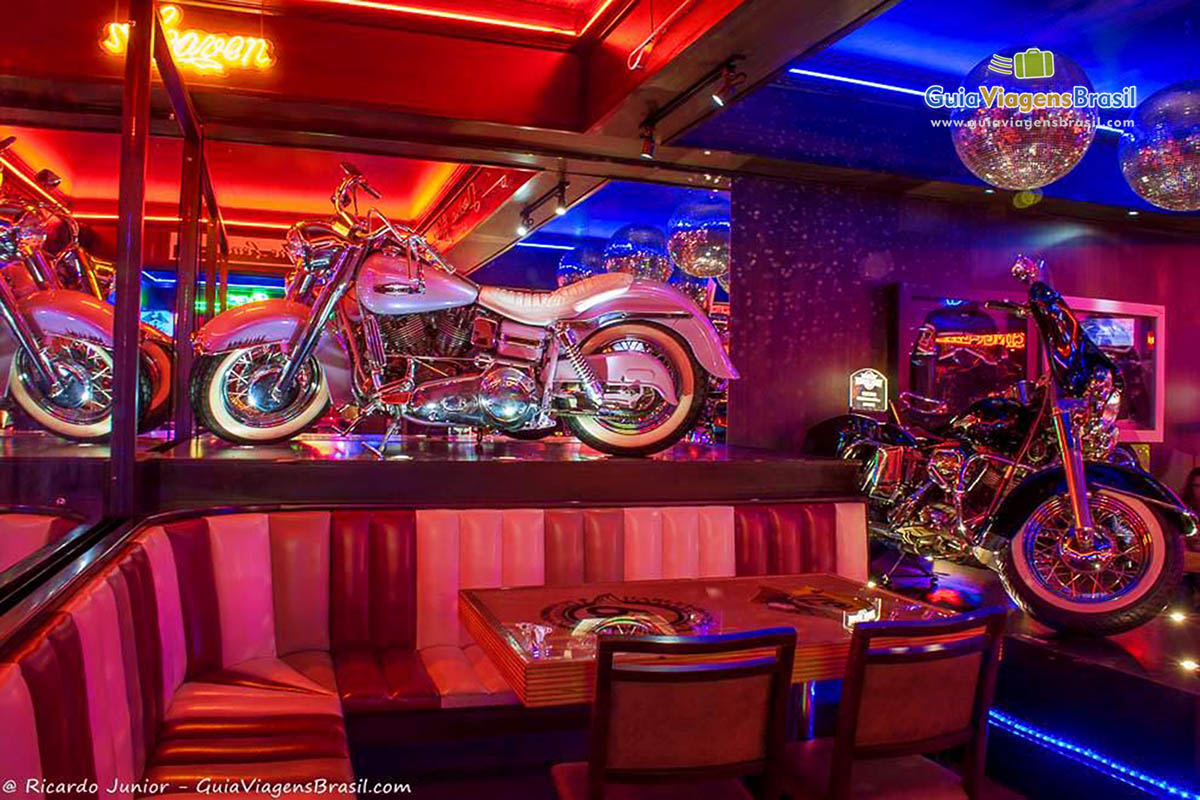 Imagem de uma belíssima moto branca na decoração no bar.