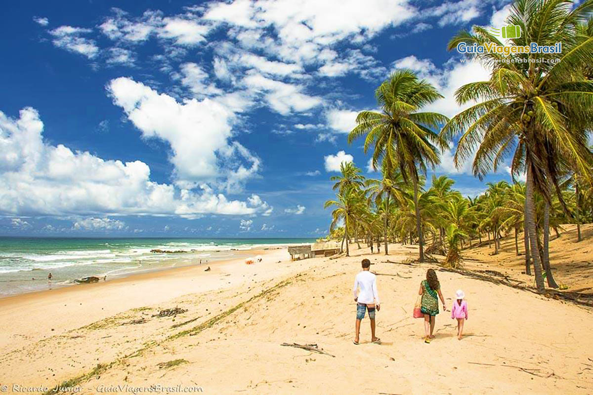 Imagem de uma família andando na linda Praia de Santo Antonio.