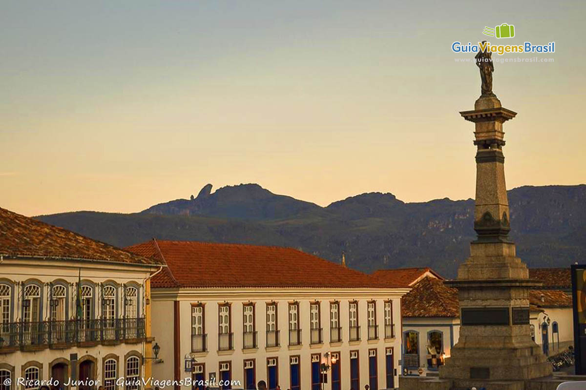 Imagem de uma Praça com monumento e ao fundo o Pico do Itacolomi, em Ouro Preto.