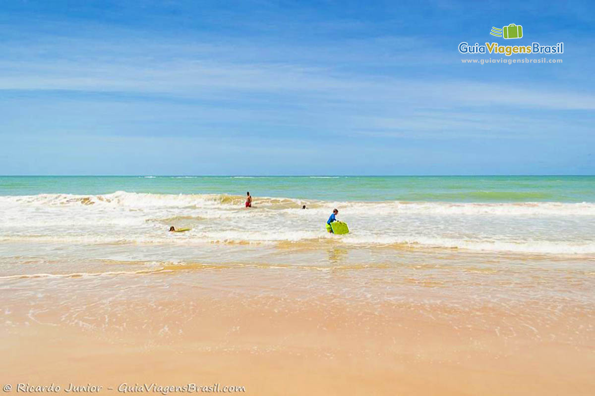 Imagem de crianças nas águas translúcidas da praia do Club Med.