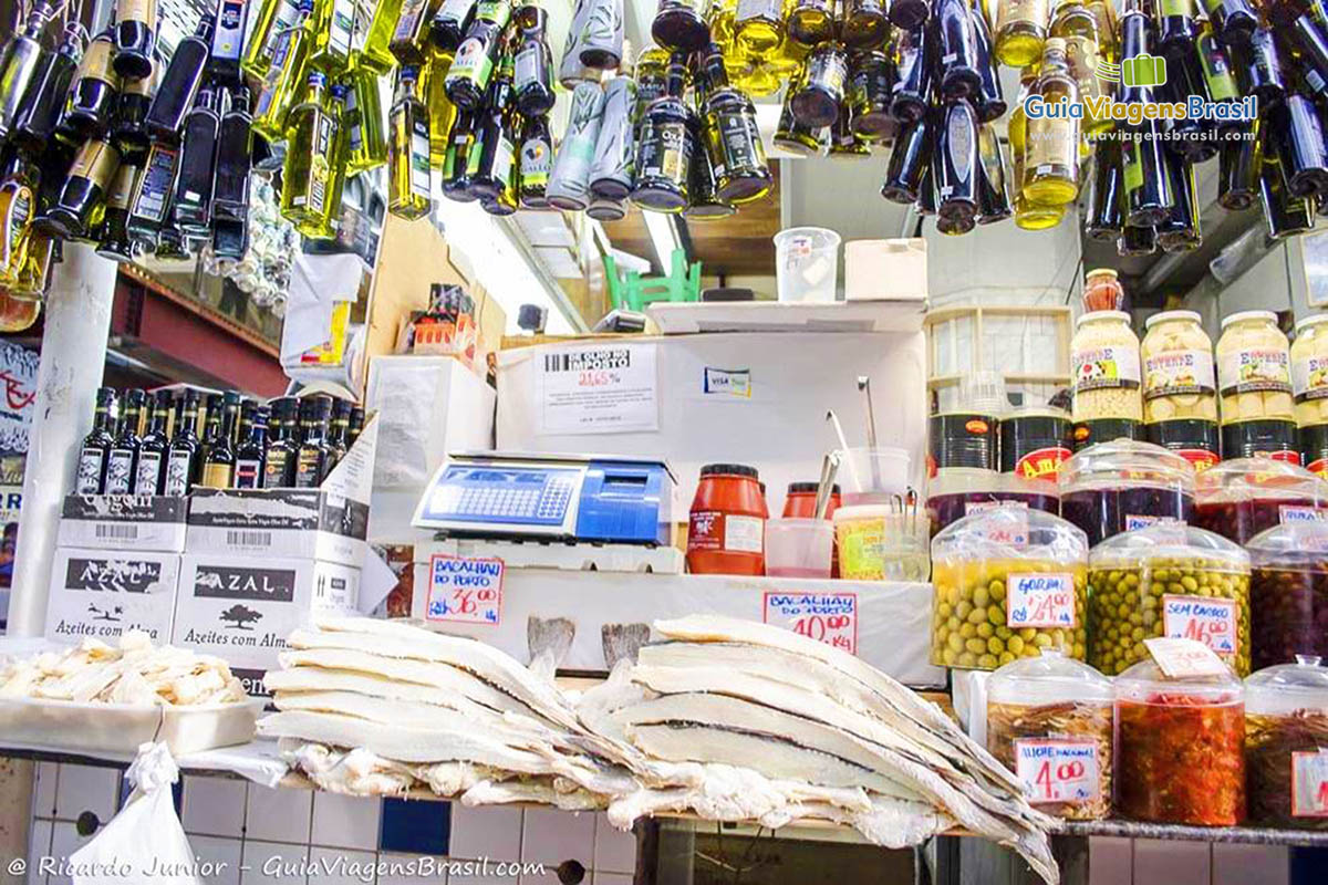 Imagem de loja que vende variedades de azeite, azeitonas e bacalhau no Mercadão, em São Paulo.