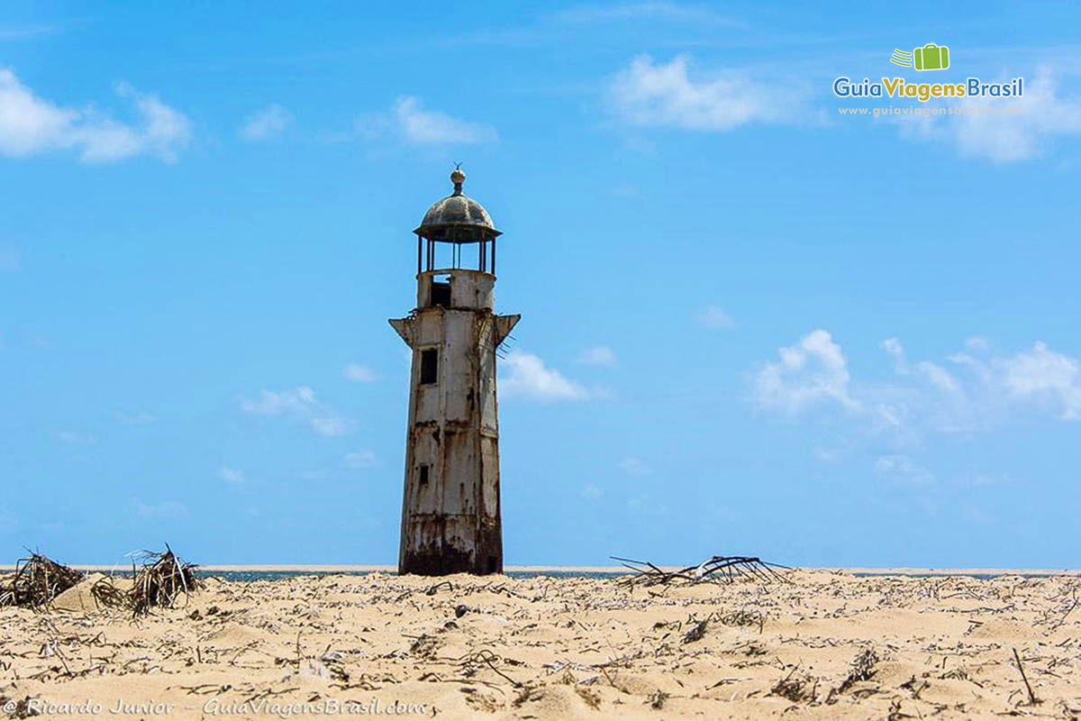 Imagem das areias da Praia Foz Rio São Francisco e ao fundo o belíssimo farol, em Alagoas, Brasil.