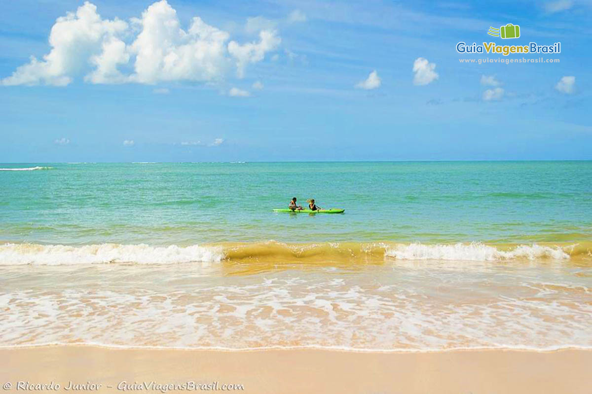 Imagem de duas pessoas de caiaque nas águas transparentes da Praia da Pitinga.