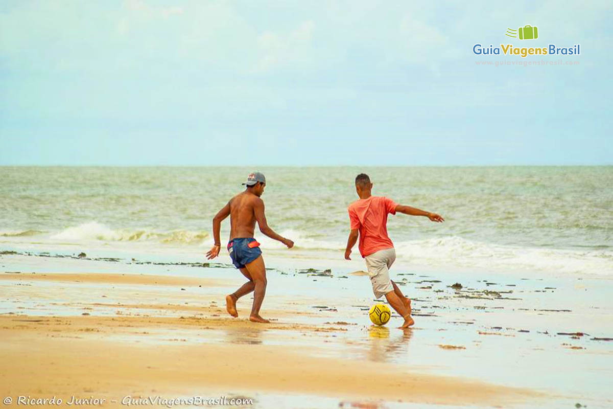 Imagem de amigos jogando bola na bela Praia de Mundaí.