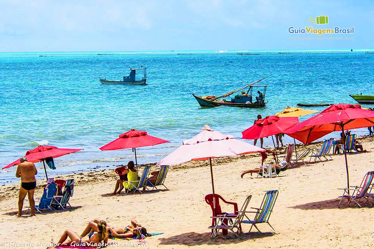 Image de vários guarda sol na areia com cadeiras fundo o mar maravilhoso da Praia de Ponta Verde, em Maceió, Alagoas, Brasil.