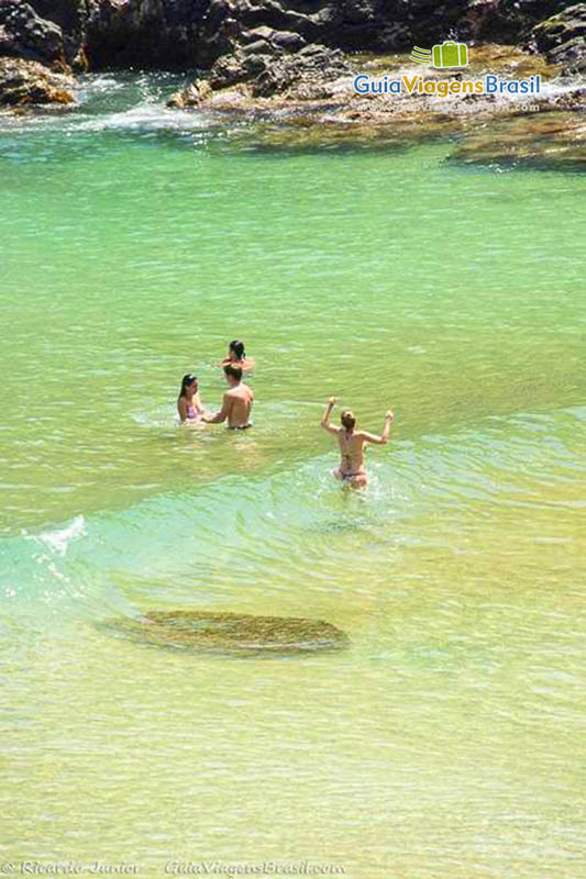 Imagem de turistas aproveitando o mar da Praia do Cachorro, em Fernando de Noronha, Pernambuco, Brasil.