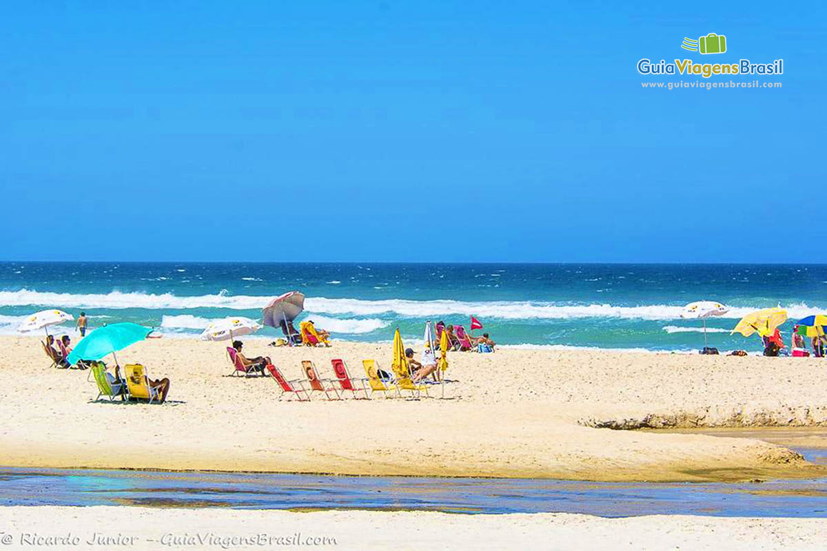 Imagem de turistas nas areia da Praia Campeche.