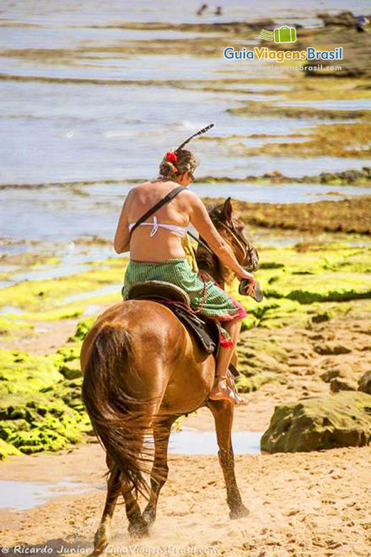 Imagem de turista andando a cavalo na Praia do Forte.
