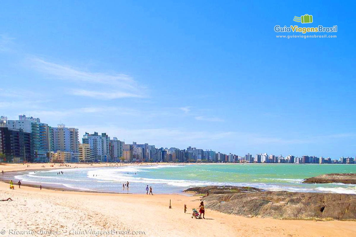 Imagem da orla da Praia do Morro, com a bela praia e ao fundo os prédios.