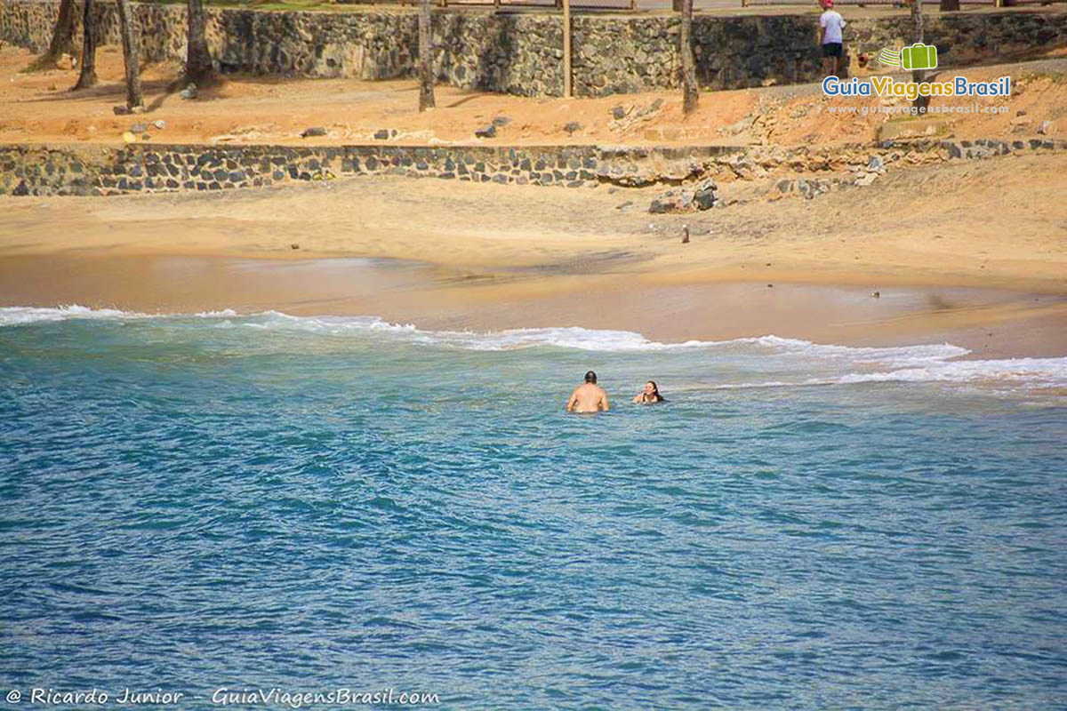 Imagem de turistas nas águas da Praia de Ondina, em Salvador.