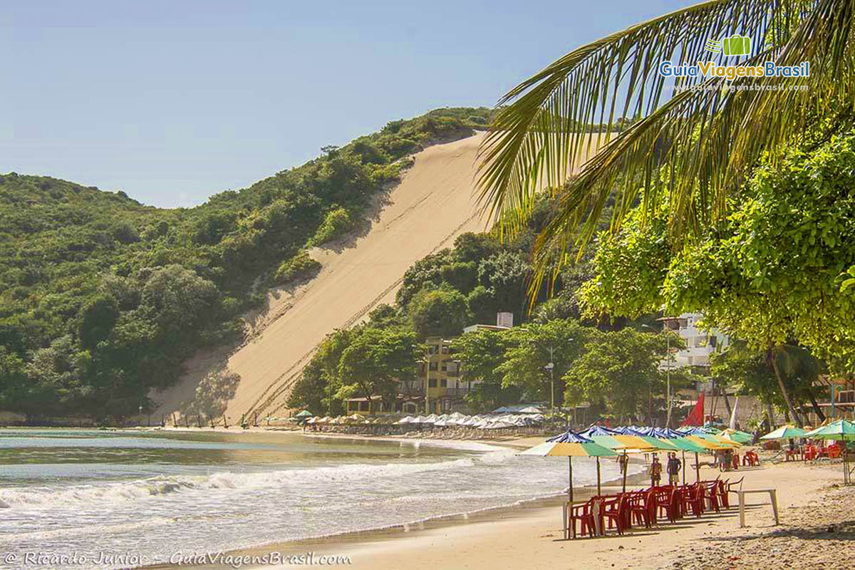 Imagem de magnífica Praia de Ponta Negra, com as dunas terminando na praia.