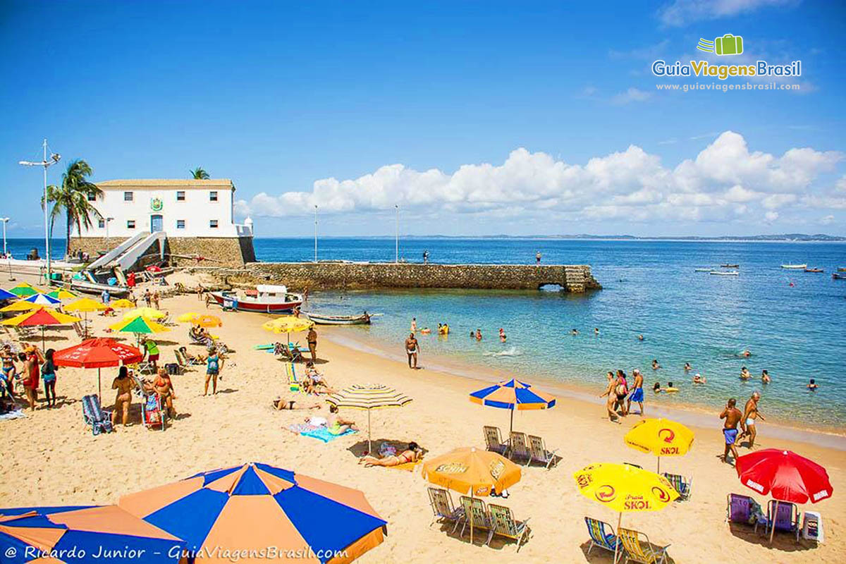 Imagem de vários guarda sol coloridos na Praia de Porto da Barra.