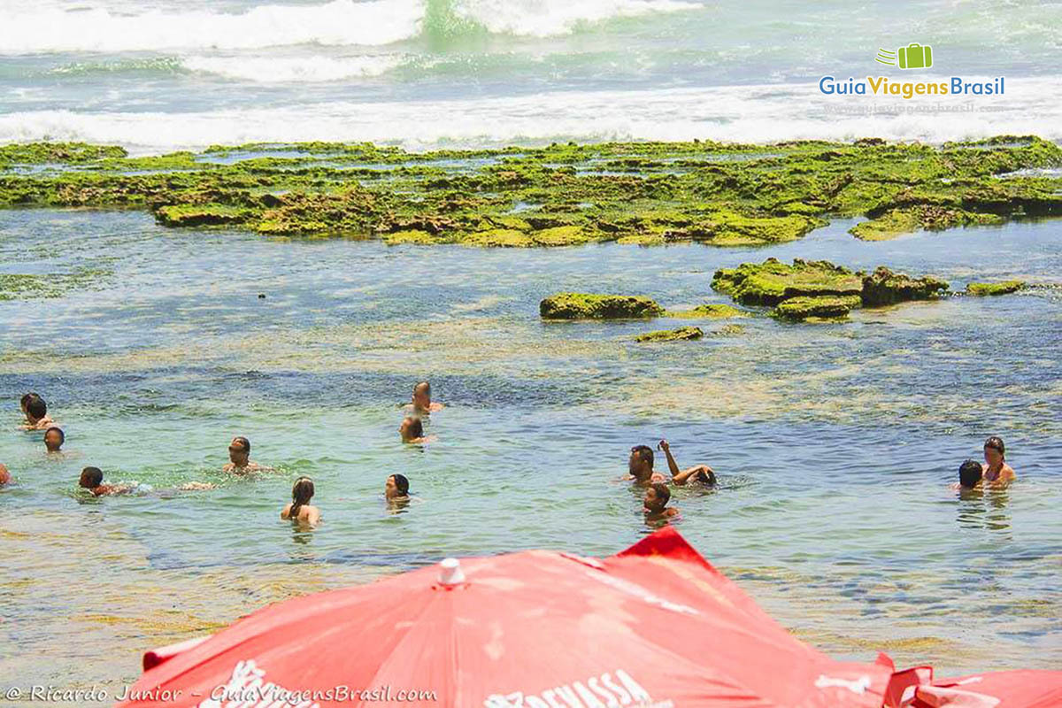 Imagem de crianças nas águas transparentes da Praia Vilas do Atlântico.