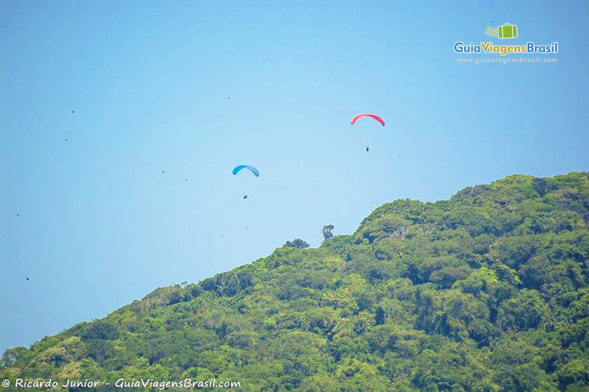 Imagem de dosi paraglider no céu da Ilha do Mel, Paraná, Brasil.