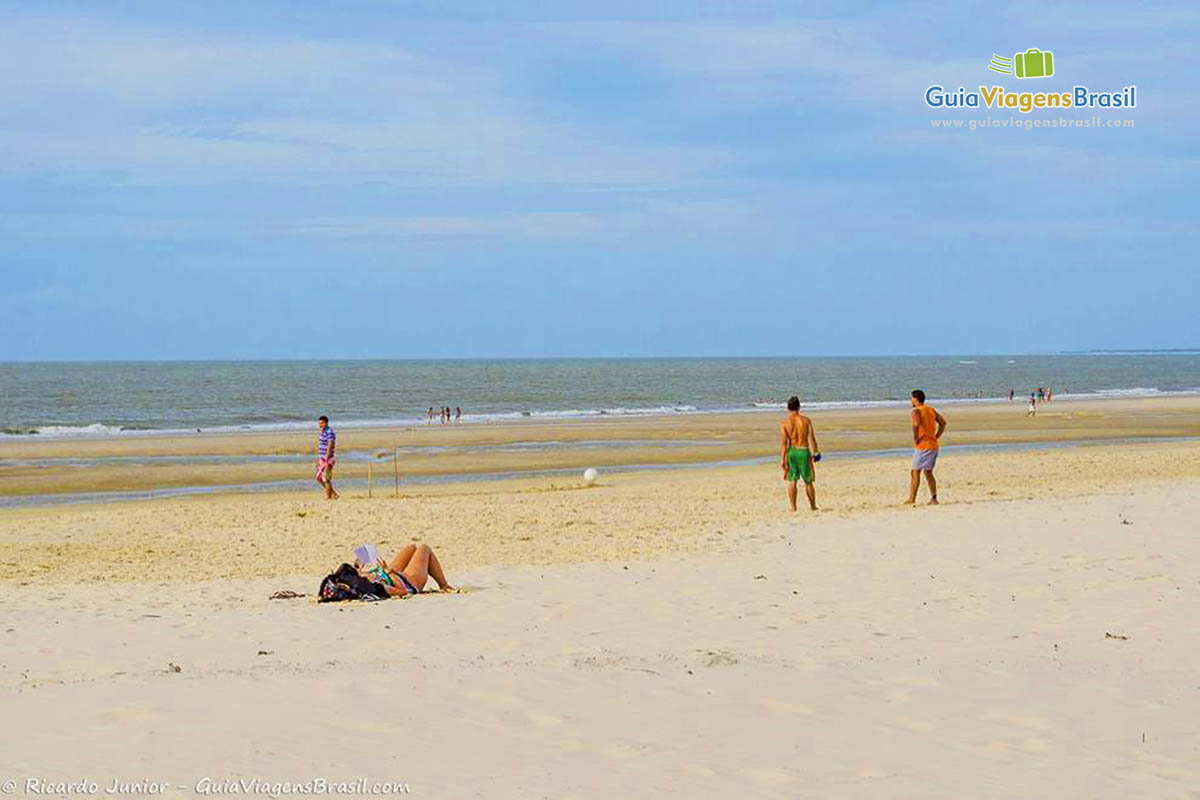 Imagem de pessoas jogando futebol nas areias da Praia São Marcos.