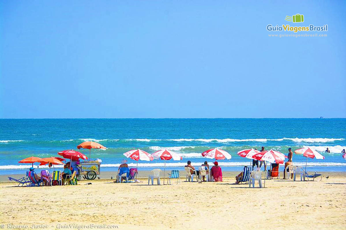 Imagem de vários guarda sol nas areias da bela Praia Grande.