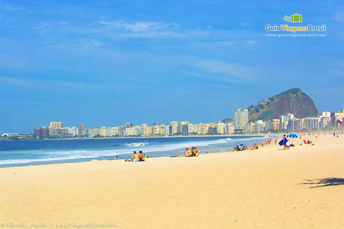 Imagem de turistas nas areias da Praia Leme aproveitando o lindo dia de sol.