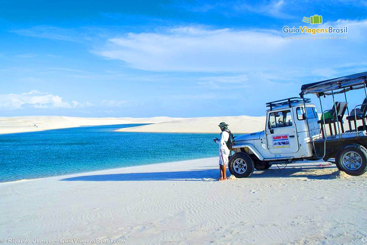 Imagem do motorista do jipe na frente do carro admirando as belezas do Maranhão.
