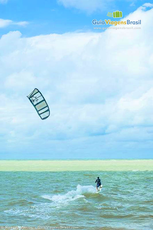 Imagem de pessoa praticando kitesurf.