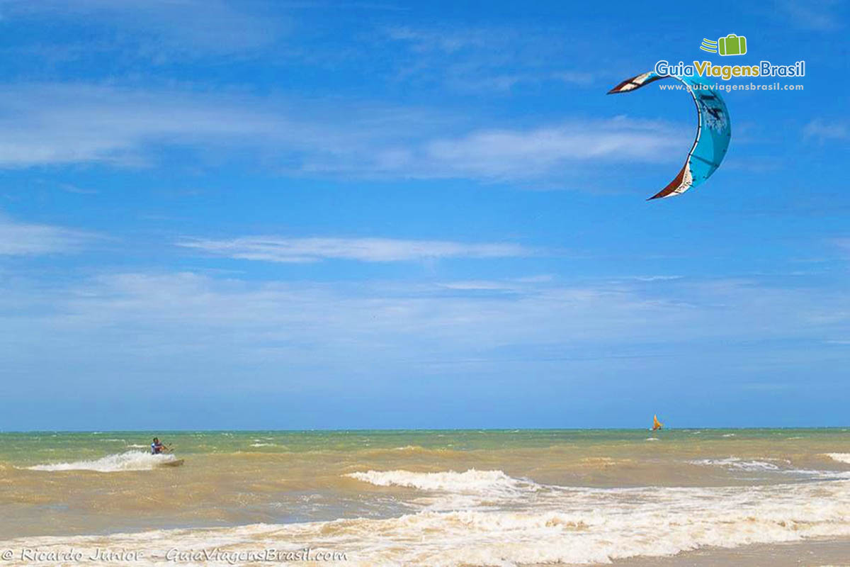 Imagem de uma pessoa praticando kitesurf na Praia Canoa Quebrada.