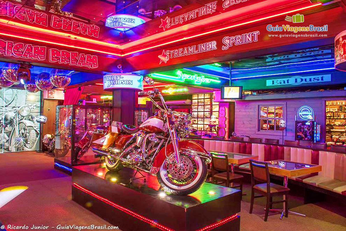 Imagem de motos espalhados pelo bar e foto de motos pela parede.