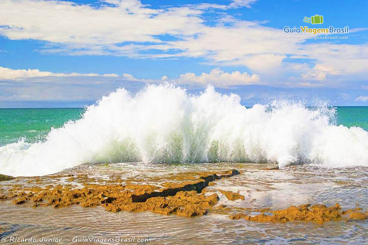 Imagem de lindas ondas batendo nos arrecifes da praia. 