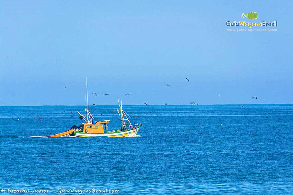 Imagem de barco de pescadores no mar azul e lindo da Praia Barra da Tijuca.