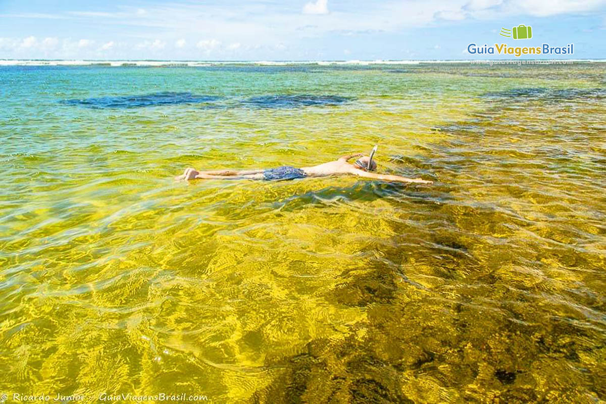 Imagem de um adulto mergulhando nas águas cristalinas da Piscinas Naturais Papa-Gente, na Praia do Forte.