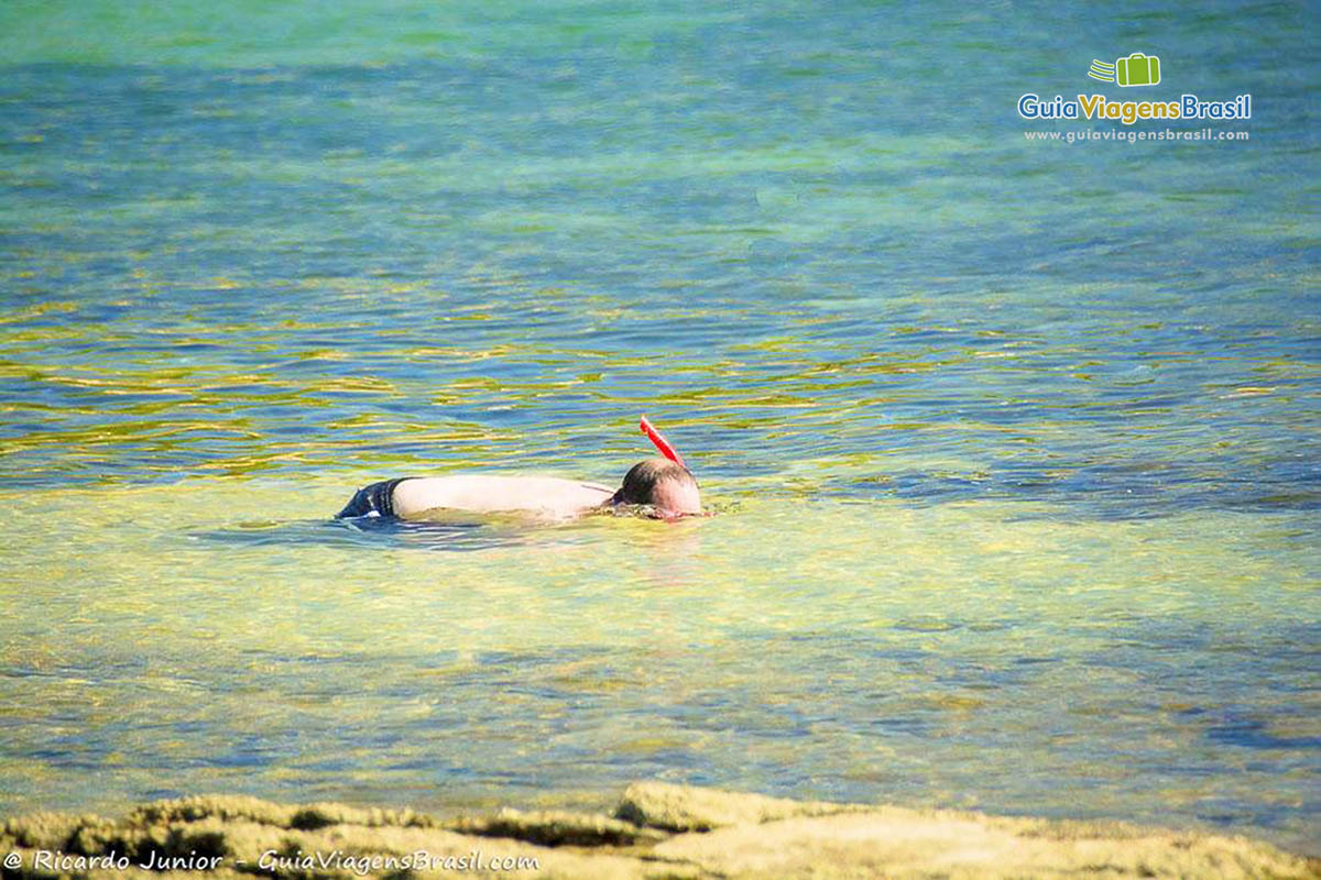 Imagem de um homem mergulhando nas águas da Praia Tartaruga.