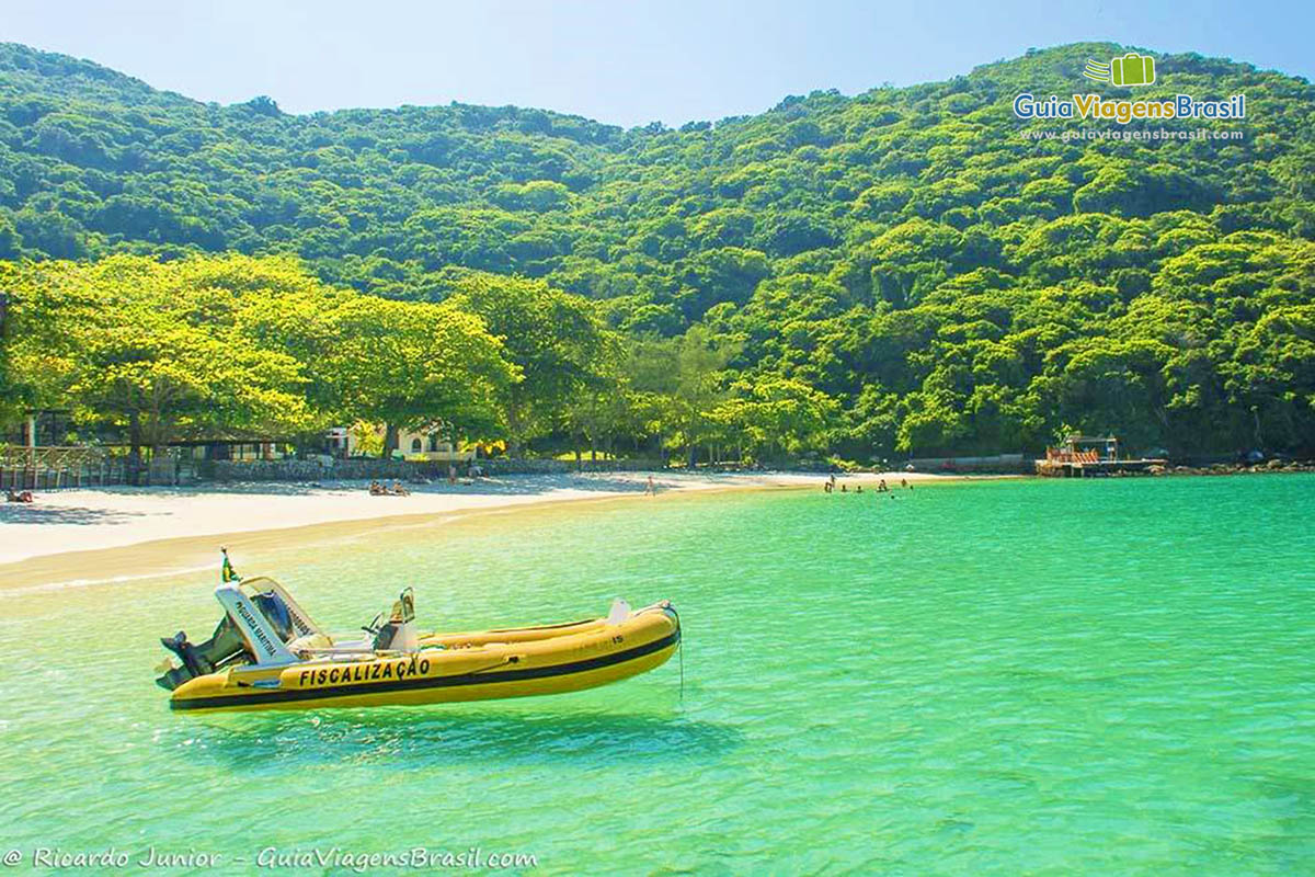 Imagem do bote amarela e a orla da Praia do Forno.