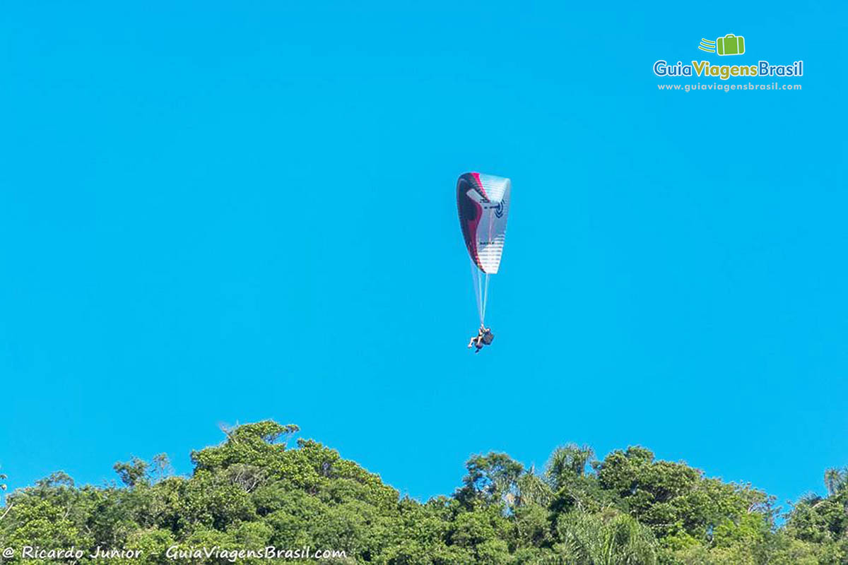 Imagem de pessoa descendo de  paraglider.