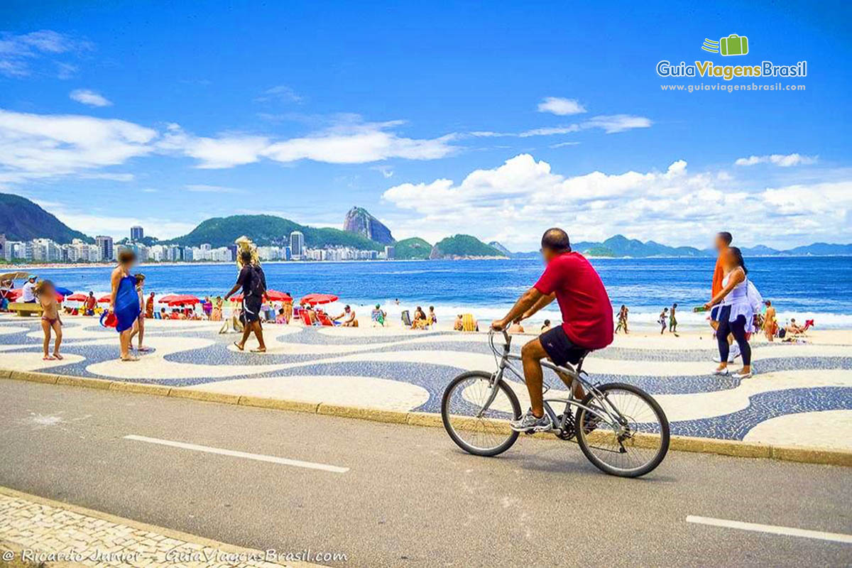 Imagem de uma pessoas passeando de bicicleta em Copacabana.