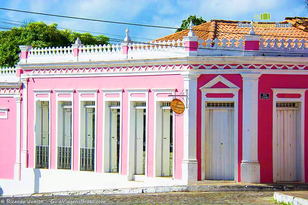 Imagem de casa rosa de esquina, belos casarões históricos.