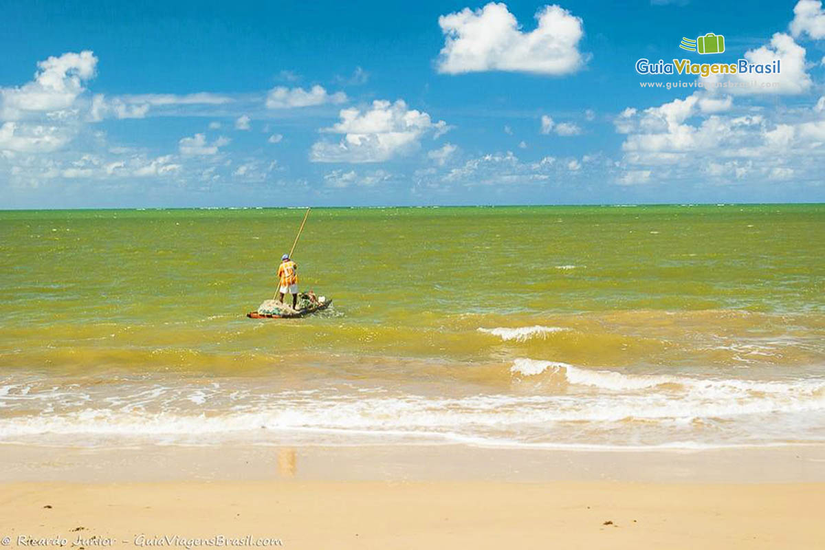 Imagem de pescador indo em direção ao alto mar na Praia Carro Quebrado.