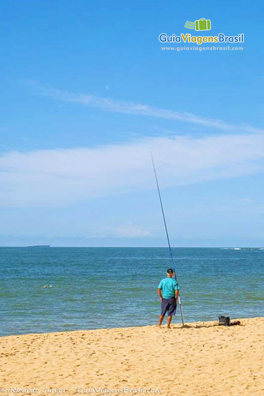 Imagem de pescador na Praia da Costa.